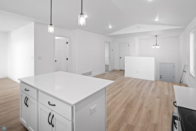 7279 26th St S, Fargo, ND 58104 - kitchen with vaulted ceiling, light wood finished floors, a kitchen island, light countertops, and pendant lighting