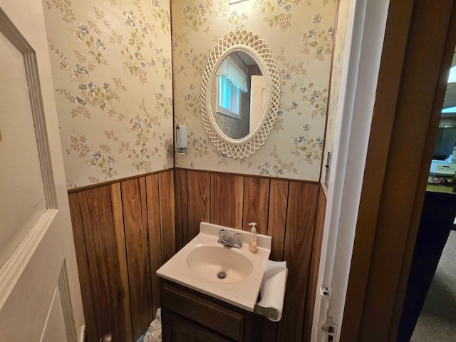 642 6th Ave, Calumet, MN 55716 - bathroom with wainscoting, wallpapered walls, wooden walls, and vanity