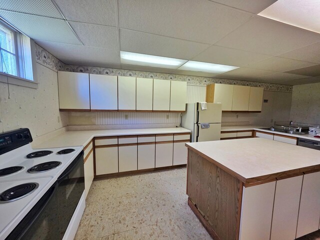 642 6th Ave, Calumet, MN 55716 - kitchen featuring electric range, freestanding refrigerator, a paneled ceiling, light countertops, and a sink