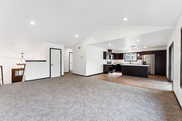 1094 7th St E, Saint Paul, MN 55106 - unfurnished living room with a chandelier, light colored carpet, lofted ceiling, recessed lighting, and a sink