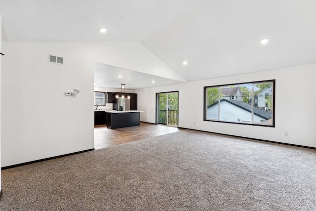 1094 7th St E, Saint Paul, MN 55106 - unfurnished living room with light colored carpet, recessed lighting, baseboards, and high vaulted ceiling