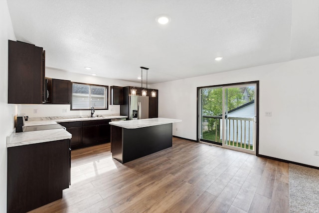1094 7th St E, Saint Paul, MN 55106 - kitchen featuring stainless steel fridge with ice dispenser, light countertops, a center island, dark brown cabinetry, and recessed lighting