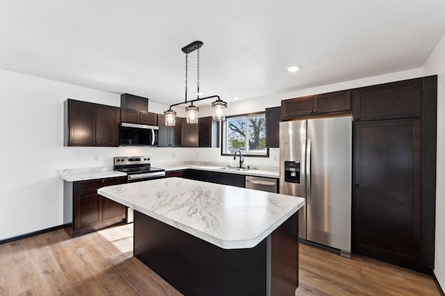 1094 7th St E, Saint Paul, MN 55106 - kitchen featuring appliances with stainless steel finishes, a sink, dark brown cabinetry, light countertops, and light wood finished floors