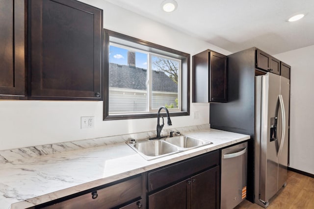 1094 7th St E, Saint Paul, MN 55106 - kitchen with stainless steel appliances, a sink, dark brown cabinetry, light wood-type flooring, and recessed lighting