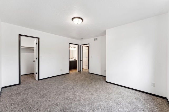1094 7th St E, Saint Paul, MN 55106 - unfurnished bedroom with carpet, baseboards, a spacious closet, and ensuite bath