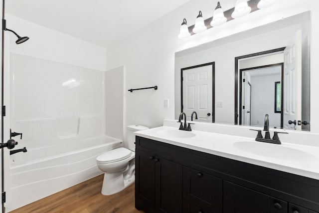1094 7th St E, Saint Paul, MN 55106 - bathroom featuring wood finished floors, toilet, double vanity, and washtub / shower combination