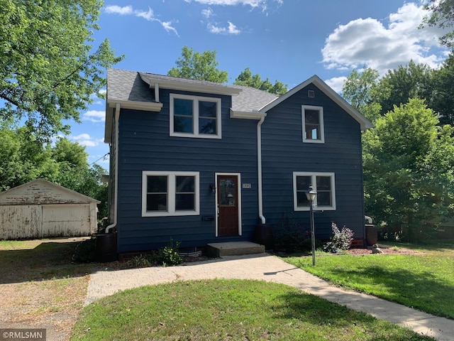 view of front of home with a front lawn and roof with shingles