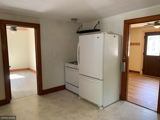 kitchen featuring white appliances, light flooring, ceiling fan, and baseboards