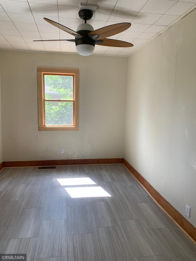 spare room with ceiling fan and baseboards