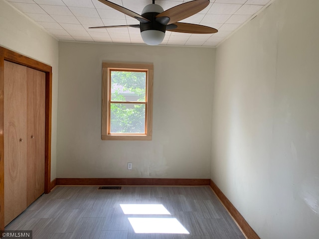 unfurnished bedroom with a closet, baseboards, and a ceiling fan