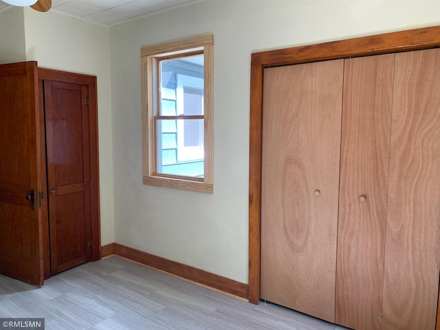 unfurnished bedroom with a closet and baseboards