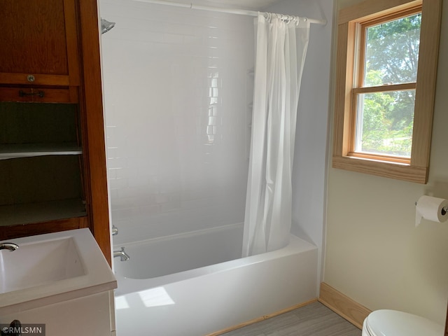 bathroom with toilet, shower / tub combo with curtain, baseboards, and vanity
