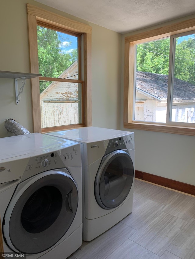 laundry room with separate washer and dryer, baseboards, and light wood-type flooring