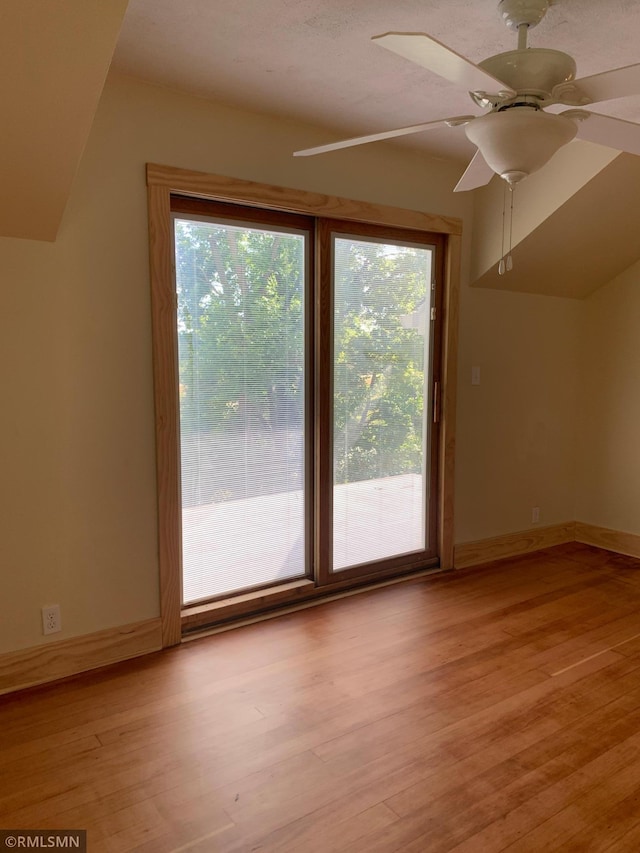 bonus room featuring light wood-style floors, a ceiling fan, and baseboards