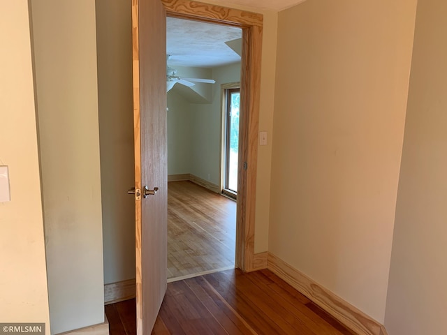 hallway featuring wood finished floors and baseboards