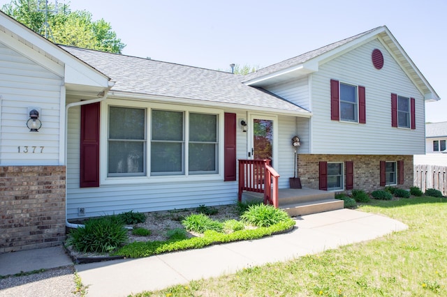 1377 Parkview Dr, New Richmond, WI 54017 - tri-level home featuring roof with shingles, brick siding, and a front yard