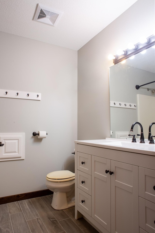 1377 Parkview Dr, New Richmond, WI 54017 - bathroom with toilet, wood finish floors, vanity, and baseboards