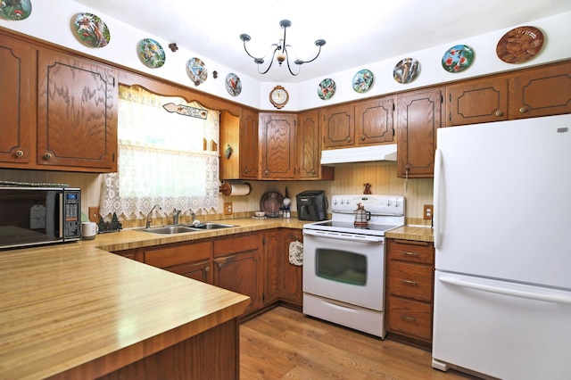 26163 170th St, New Richland, MN 56072 - kitchen with white appliances, under cabinet range hood, a chandelier, a sink, and light wood-type flooring