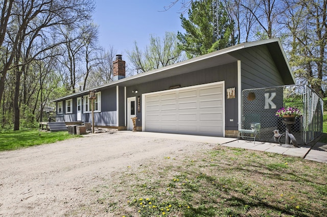26163 170th St, New Richland, MN 56072 - view of front of house with dirt driveway, a chimney, and an attached garage