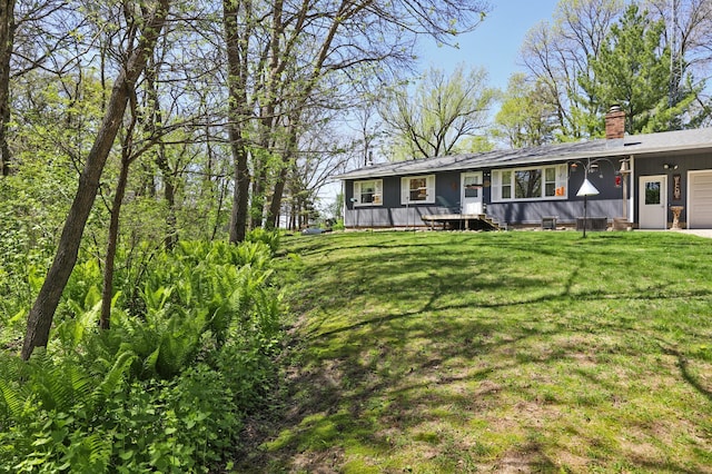26163 170th St, New Richland, MN 56072 - view of front facade with a garage, a chimney, and a front lawn