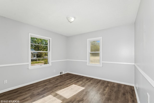 spare room with dark wood finished floors and baseboards