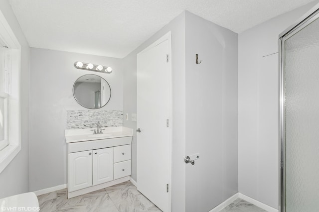 bathroom with marble finish flooring, vanity, baseboards, and a textured ceiling