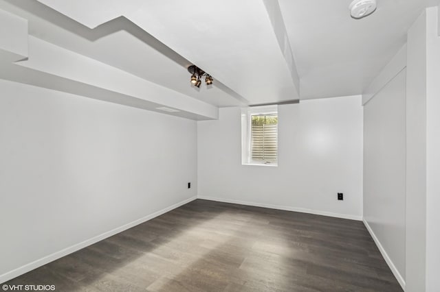 additional living space with dark wood-style floors and baseboards