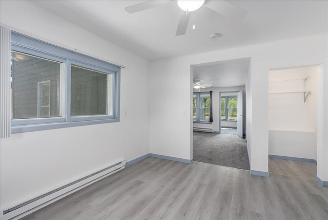 231 High St, New Richmond, WI 54017 - spare room with baseboard heating, a ceiling fan, wood finished floors, and baseboards