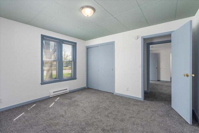 231 High St, New Richmond, WI 54017 - unfurnished bedroom with baseboard heating, carpet flooring, baseboards, a closet, and a drop ceiling
