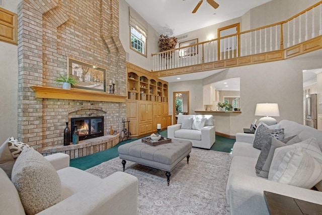 2 Pleasant Lake Rd, North Oaks, MN 55127 - carpeted living room with a high ceiling, built in shelves, a ceiling fan, and a brick fireplace