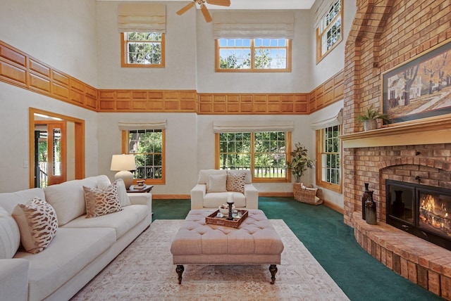 2 Pleasant Lake Rd, North Oaks, MN 55127 - living room featuring a towering ceiling, carpet flooring, a brick fireplace, and a ceiling fan