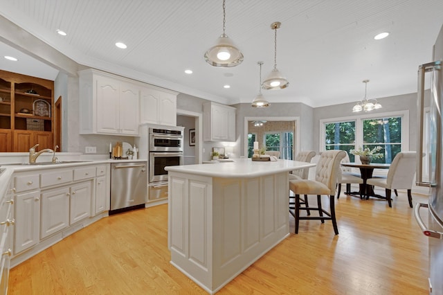 2 Pleasant Lake Rd, North Oaks, MN 55127 - kitchen featuring appliances with stainless steel finishes, white cabinets, light wood-type flooring, a chandelier, and light countertops