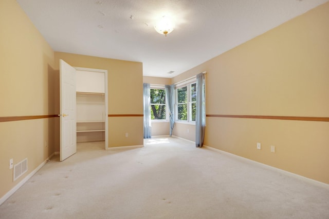 2 Pleasant Lake Rd, North Oaks, MN 55127 - unfurnished bedroom featuring light colored carpet, a spacious closet, and a closet