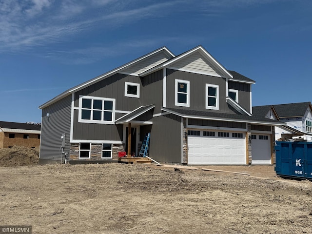 view of front of house featuring an attached garage and stone siding