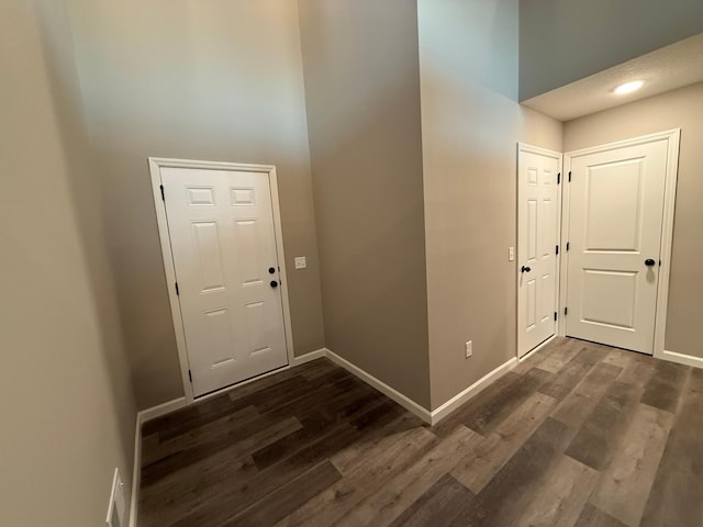 foyer entrance with dark wood finished floors and baseboards