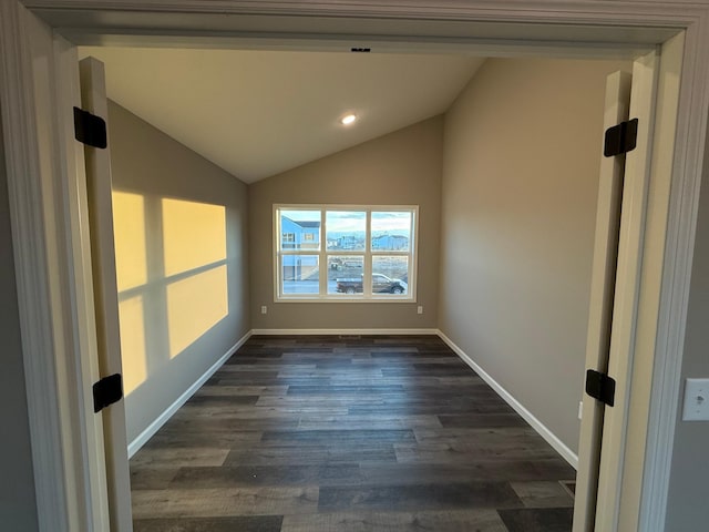 spare room featuring dark wood finished floors, vaulted ceiling, recessed lighting, and baseboards