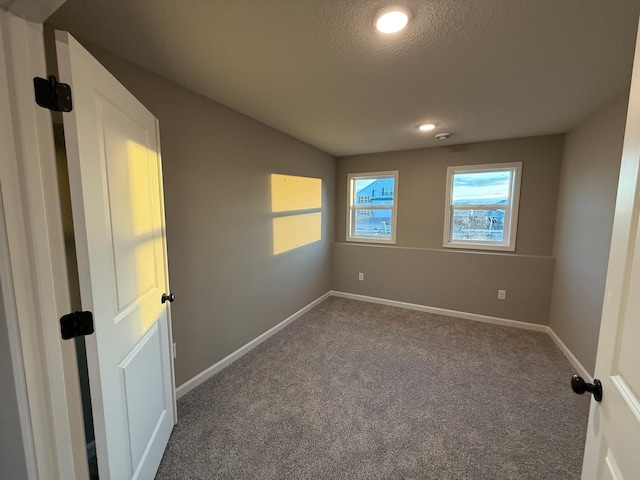 unfurnished room featuring a textured ceiling, carpet, baseboards, and recessed lighting