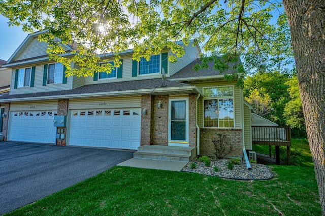 6147 Tahoe Cir Unit A, Woodbury, MN 55125 - multi unit property featuring asphalt driveway, a front yard, an attached garage, and brick siding