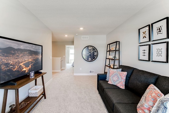 carpeted living area featuring baseboards, a textured ceiling, and recessed lighting