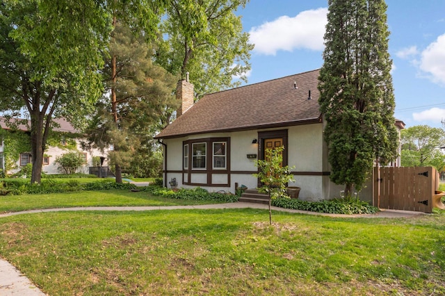 3338 Brownlow Ave, Saint Louis Park, MN 55426 - english style home featuring stucco siding, a front yard, a chimney, and roof with shingles