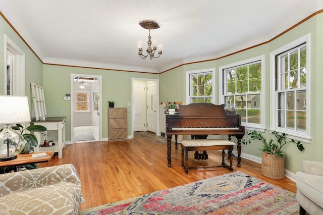 3338 Brownlow Ave, Saint Louis Park, MN 55426 - sitting room with baseboards, a chandelier, wood finished floors, and ornamental molding