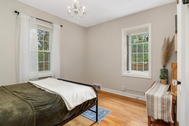 3338 Brownlow Ave, Saint Louis Park, MN 55426 - bedroom featuring multiple windows, a chandelier, baseboards, and light wood finished floors