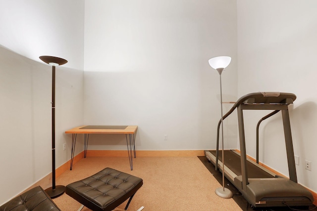 workout area featuring carpet and baseboards
