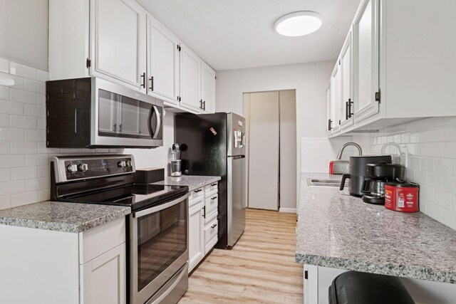 4430 Cedar Lake Rd S Unit 6, Saint Louis Park, MN 55416 - kitchen featuring stainless steel appliances, backsplash, light wood-style flooring, and white cabinets