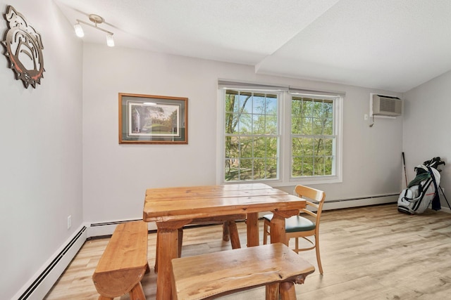 4430 Cedar Lake Rd S Unit 6, Saint Louis Park, MN 55416 - dining area featuring a baseboard radiator, an AC wall unit, light wood finished floors, and a textured ceiling
