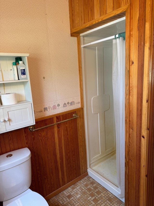 27721 Northwoods Dr, Laporte, MN 56461 - bathroom featuring a stall shower, toilet, wainscoting, wood walls, and wallpapered walls