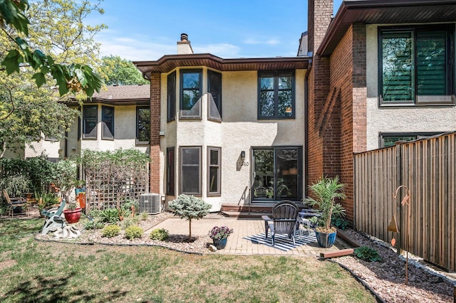 1940 Dupont Ave S, Minneapolis, MN 55403 - rear view of house with a chimney, cooling unit, stucco siding, and a patio