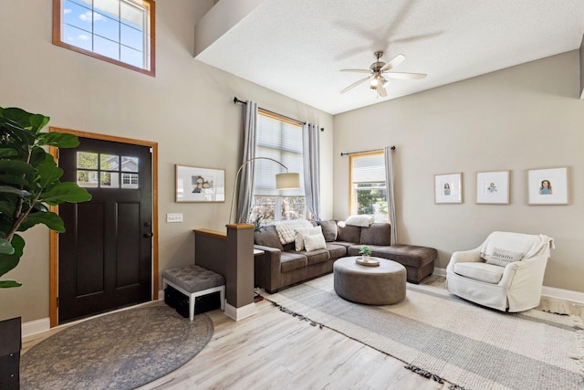 living room with ceiling fan, wood finished floors, and baseboards