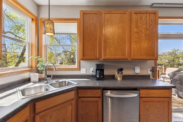 kitchen with dishwasher, a sink, dark countertops, and pendant lighting