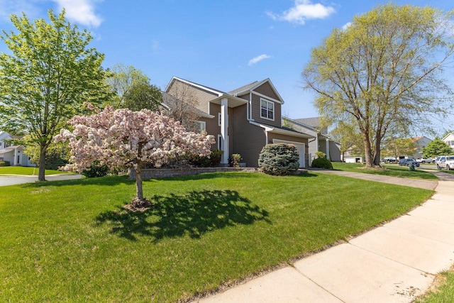 view of front of property with concrete driveway, a front lawn, and a garage